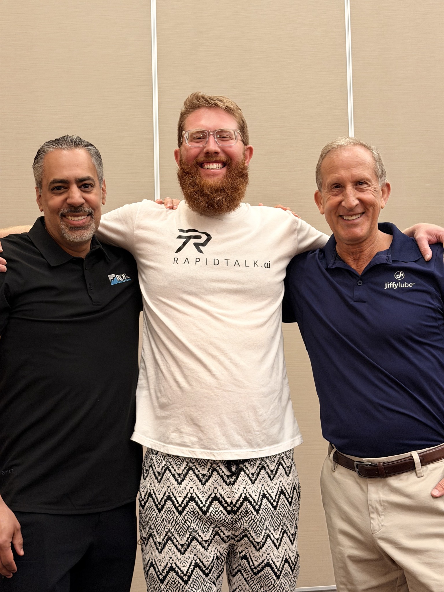 Tomas with two others wearing RapidTalk and Jiffy Lube shirts