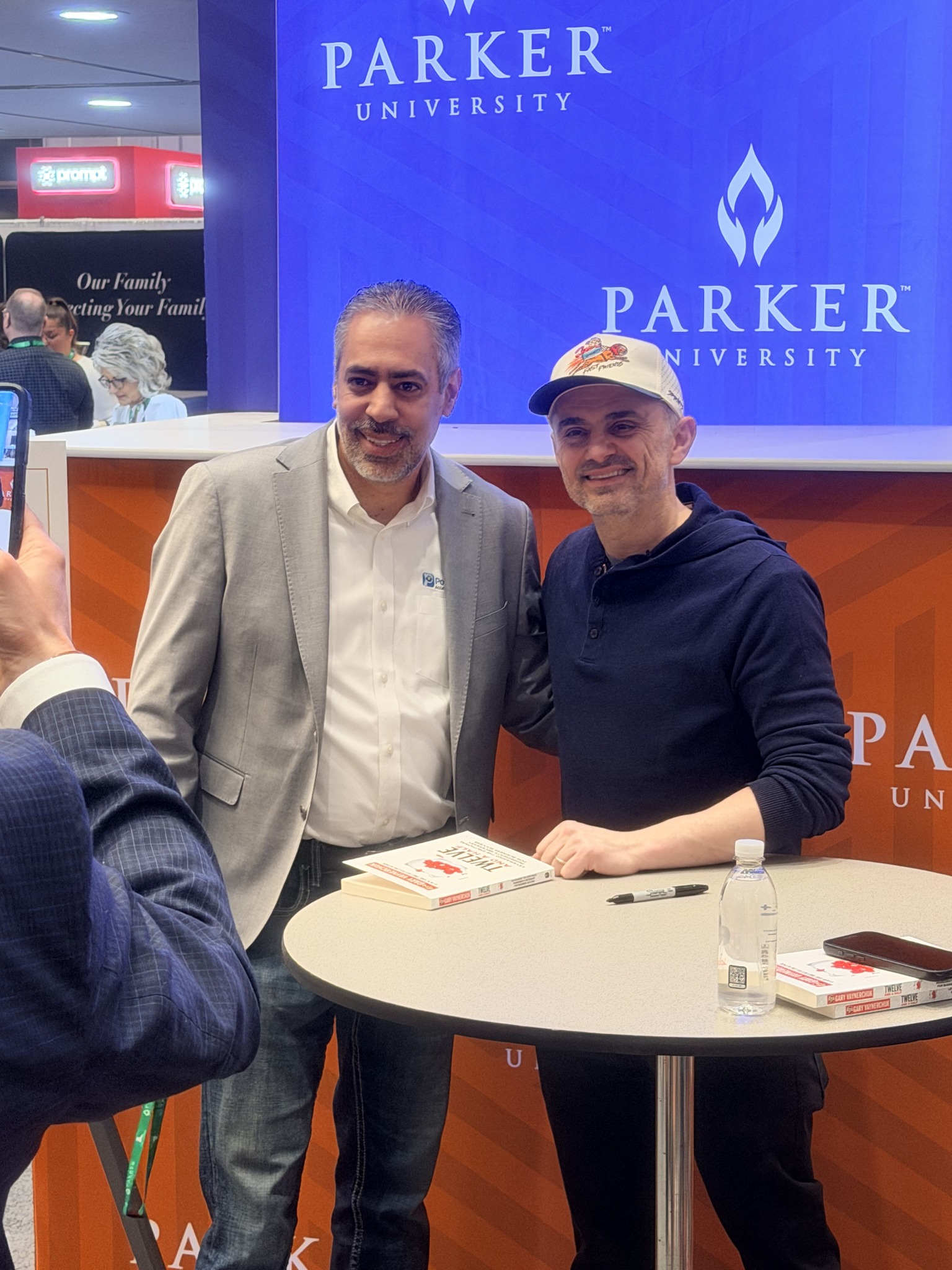 Tomas beside a book-signing table at an event